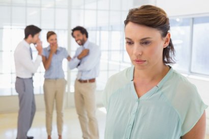 Colleauges_gossiping_with_sad_businesswoman_in_foreground_xs.jpg